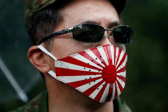 A right-wing activist wearing a rising sun face mask visits Yasukuni Shrine on the 76th anniversary of Japan's surrender in World War Two, amid the coronavirus disease (COVID-19) pandemic, in Tokyo, Japan on August 15, 2021. (Photo by Issei Kato/Reuters)