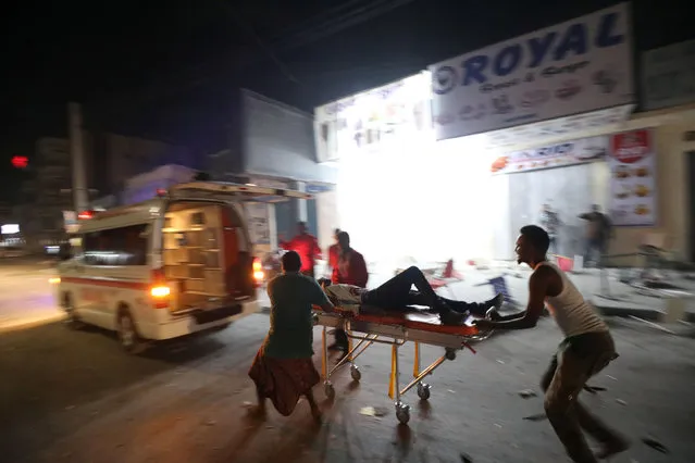 An injured man is evacuated from the scene where a suicide car bomb exploded targeting a Mogadishu hotel in a business center in Maka Al Mukaram street in Mogadishu, Somalia on February 28, 2019. (Photo by Feisal Omar/Reuters)