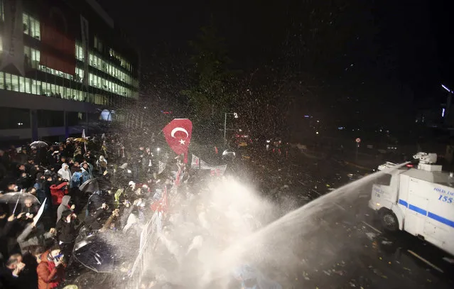 Riot police use water canon against people gathered in support of Turkey's largest-circulation newspaper Zaman at its headquarters in Istanbul, early Saturday, March 5, 2016. The police raid came hours after a court placed it under the management of trustees on Friday. The move against the paper, which is linked to an opposition cleric, heightened concerns over deteriorating press freedoms in the country. (Photo by AP Photo)