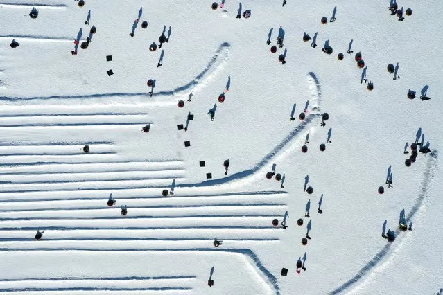 An aerial view shows people playing in the snow with tubes at a park in Shenyang, in northeastern China's Liaoning province on February 4, 2024. (Photo by AFP Photo/China Stringer Network)