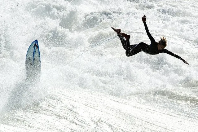 A surfer jumps off his board into a wave just south of the Huntington Beach Pier in Huntington Beach, Calif., Tuesday, October 26, 2021, following Monday's storm. (Photo by Mark Rightmire/The Orange County Register via AP Photo)