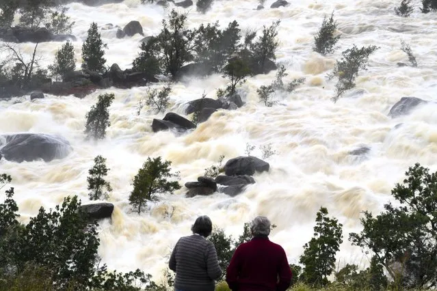 Locals take a look at overflow water spills from Wyangala Dam near the NSW town of Cowra, Monday, November 15, 2021. The NSW State Emergency Service has warned locals in up to 800 homes in towns along the Lachlan River to be prepared for evacuation. (Photo by Lukas Coch/AAP Image)