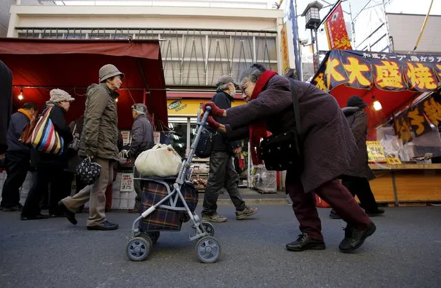 An elderly woman pushes a walking aid as she walks on a street at Tokyo's Sugamo district, an area popular among the Japanese elderly, in Tokyo in this January 14, 2015 file photo. Japan is laying the groundwork for new government spending to pre-empt any weakness in household consumption, and could set an early example after the Group of 20 nations called for more fiscal spending to help support the ailing global economy. (Photo by Toru Hanai/Reuters)