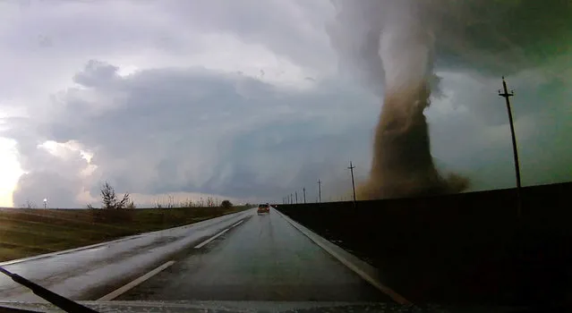 A column of sand and front of clouds are seen by dash cam as the car drives near a tornado in Dragalina, Calarasi county, Romania April 30, 2019 in this still image taken from a video obtained from social media. (Photo by Alexandra Puscasu via Reuters)