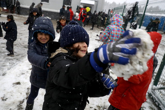 Migrant children play with snow at transport and logistics centre near the Belarusian-Polish border in the Grodno region, Belarus on November 23, 2021. (Photo by Kacper Pempel/Reuters)