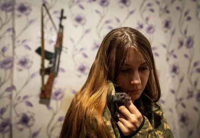 A Ukrainian Army liaison officer Vira, 22, plays with her rat Malyi (Tiny) at her positions near a frontline, in Donetsk region, Ukraine, on March 8, 2024. (Photo by Inna Varenytsia/Reuters)