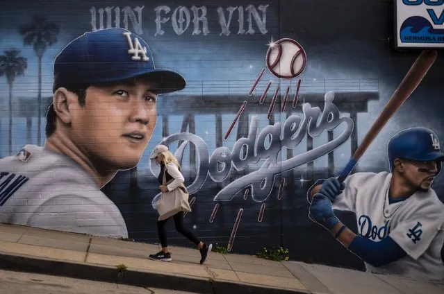 A woman walks past a mural of Los Angeles Dodgers' Shohei Ohtani, left, and Mookie Betts, painted by artist Gustavo Zermeno Jr., in Hermosa Beach, Calif., Monday, March 18, 2024. The Dodgers and the San Diego Padres play Major League Baseball's first regular-season games in Seoul, South Korea on March 20-21. (Photo by Jae C. Hong/AP Photo)