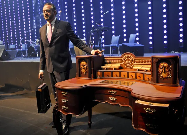 Spain's Javier Gonzalez Lera (2nd L) pose after auctioned the “humidor” (humidifier for Havana cigar) for 170 thousand euros during the traditional “humidor” auction in the XVI Havana Cigar Festival, in Havana on February 28, 2014. The production of Cuban cigars experienced an eight percent growth in 2013 adding 447 million dollars to the Cuban economy. (Photo by Yamil Lage/AFP Photo)