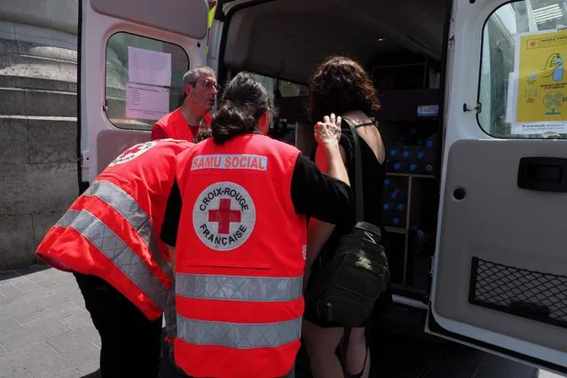 The French Red Cross assists a woman in front of the main train station of Tours on June 27, 2019 where they distribute water and fruits during a heatwave. Europeans braced on June 27 for the expected peak of a sweltering heatwave that has sent temperatures soaring above 40 degrees Celsius (104 Fahrenheit), with schools in France closing and wildfires in Spain spinning out of control. (Photo by Guillaume Souvant/AFP Photo) 