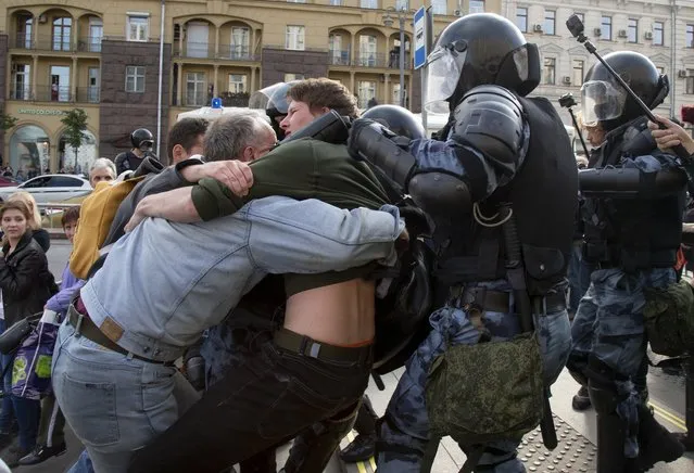 Police officers try to detain protestors during an unsanctioned rally in the center of Moscow, Russia, Saturday, August 3, 2019. Moscow police detained more than 300 people Saturday who are protesting the exclusion of some independent and opposition candidates from the city council ballot, a monitoring group said. (Photo by Alexander Zemlianichenko/AP Photo)