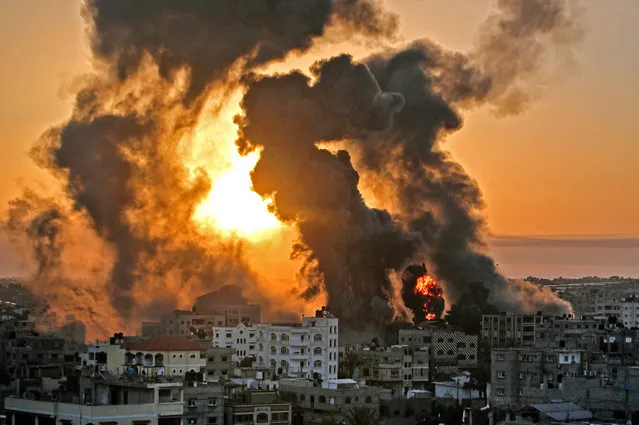 A fire rages at sunrise in Khan Yunish following an Israeli airstrike on targets in the southern Gaza strip, early on May 12, 2021. Israeli air raids in the Gaza Strip have hit the homes of high-ranking members of the Hamas militant group, the military said Wednesday, with the territory's police headquarters also targeted. (Photo by Youssef Massoud/AFP Photo)