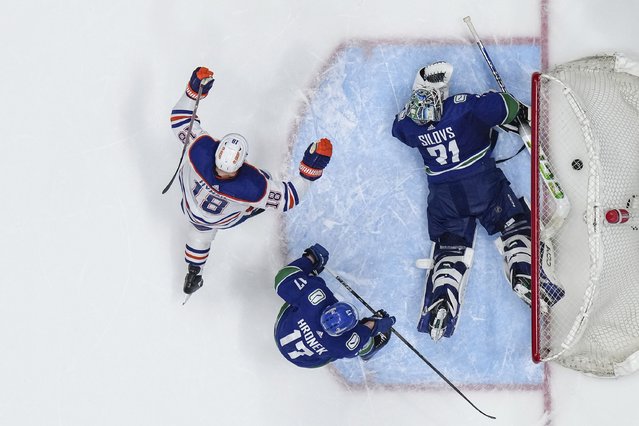 Edmonton Oilers' Zach Hyman (18) celebrates a goal by teammate Ryan Nugent-Hopkins, not pictured, against Vancouver Canucks goalie Arturs Silovs (31) as Filip Hronek (17) looks on during the second period in Game 7 of an NHL hockey Stanley Cup second-round playoff series, in Vancouver, British Columbia, Canada, on Monday, May 20, 2024. (Photo by Darryl Dyck/The Canadian Press via AP Photo)