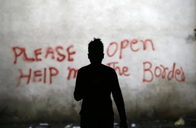 A migrant walks through an abandoned warehouse that has served as a make-shift shelter for hundreds of men trying to reach Western Europe, in Belgrade, Serbia, Tuesday, March 21, 2017. Thousands of migrants have been stranded in Serbia looking for ways to reach western Europe. Many have tried several times to cross to Hungary or Croatia. (Photo by Darko Vojinovic/AP Photo)