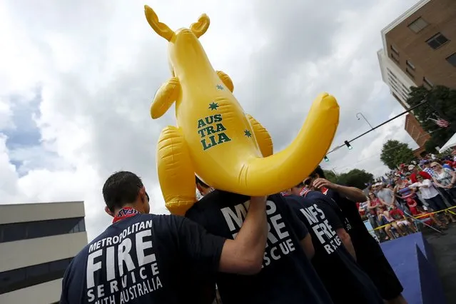 The team from the South Australian Country Fire Service in Melbourne hold an inflatable kangaroo as they accept their third-place medals in the bucket brigade competition during the Firefighter Muster event at the World Fire and Police Games in Fairfax, Virginia July 4, 2015. (Photo by Jonathan Ernst/Reuters)