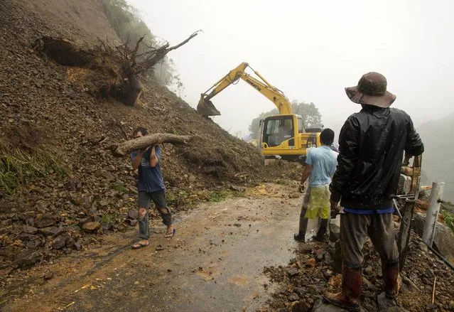 Government workers clear a portion of Kennon Road after heavy rains brought by tropical storm Linfa caused landslides in Tuba, Benguet, in northern Philippines July 6, 2015. (Photo by Harley Palangchiao/Reuters)
