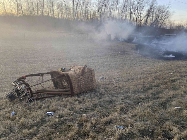 The basket from a hot air balloon that crashed, rests near Highway 63 in Rochester, Minn. on Wednesday, March 20, 2023. Three people in a hot air balloon escaped largely unscathed after their basket clipped a power line, fell to the ground and caused a brush fire.  (Photo by Rochester Fire Department via AP Photo)