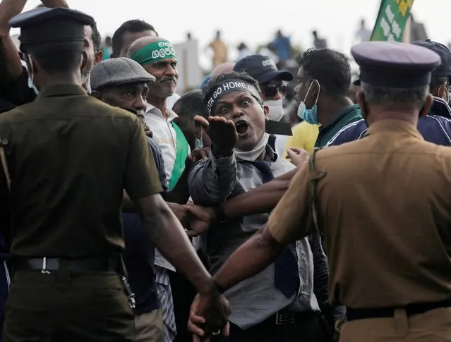 A man shouts against President Gotabaya Rajapaksa as people block the main road in front of the President's secretariat during a protest organised by main opposition party Samagi Jana Balawegaya against the worsening economic crisis that has brought fuel shortages and spiralling food prices in Colombo, Sri Lanka, March 15, 2022. (Photo by Dinuka Liyanawatte/Reuters)