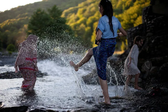 Girls who are cousins of Mariam Kebadze (not pictured), play in Alazani river in Dzibakhevi village of Pankisi, Georgia, July 3, 2019. The three girls live in Grozny, Chechnya. They came to Pankisi for the first time, met Mariam and her mother Leila Achishvili, the owner of Leila's Guesthouse, and are spending summer there. (Photo by Ekaterina Anchevskaya/Reuters)