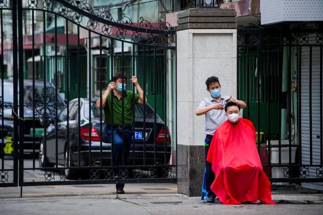 A resident gets haircut on a street during lockdown amid the coronavirus disease (COVID-19) pandemic, in Shanghai, China, May 30, 2022. (Photo by Aly Song/Reuters)