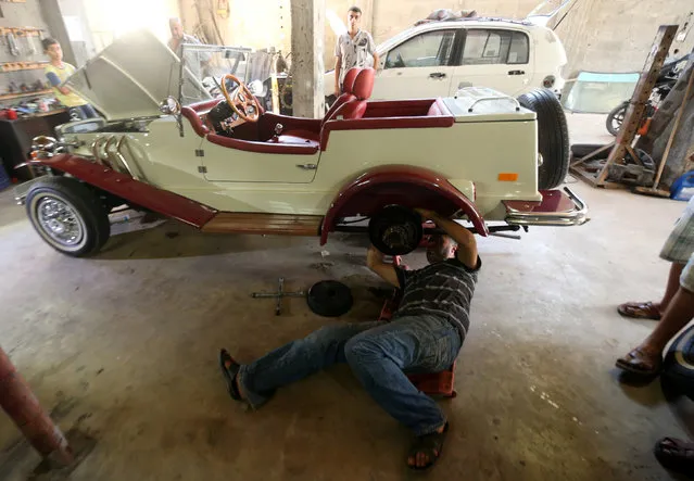 Palestinian Munir Shindi, 36, checks a replica of a 1927 Mercedes Gazelle that he built from scratch, in his workshop in Gaza City June 19, 2016. (Photo by Mohammed Salem/Reuters)