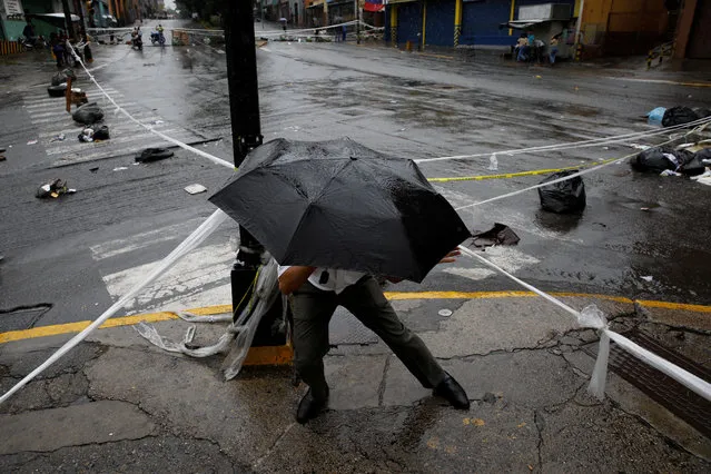 A pedestrian walks through a barricade during a rally against Venezuelan President Nicolas Maduro's government in Caracas, Venezuela on July 19, 2017. (Photo by Carlos Garcia Rawlins/Reuters)