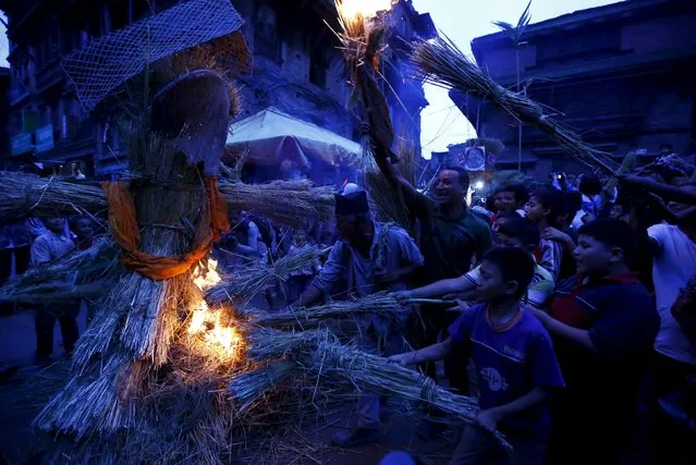People set fire to the effigy of the demon Ghantakarna, during the Ghantakarna festival at the ancient city of Bhaktapur, Nepal August 12, 2015. (Photo by Navesh Chitrakar/Reuters)