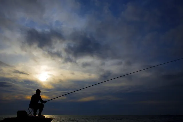 A man casts his fishing pole from a rocky coastal area along the Beirut coastline, Lebanon, Thursday, May 25, 2017. (Photo by Hassan Ammar/AP Photo)