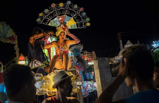 In this July 25, 2015 photo, a woman in costume prepares for the carnival parade to start in Santiago, Cuba. Low visitor numbers to Santiago are raising concerns that a rising tide of tourist dollars will leave some areas of Cuba booming and others struggling against a backgroup of broader economic stagnation. (Photo by Ramon Espinosa/AP Photo)