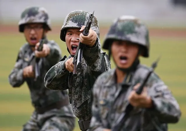 People's Liberation Army (PLA) soldiers shout as they hold guns and practise in a drill during a organized media tour at a PLA engineering school in Beijing, July 22, 2014. (Photo by Petar Kujundzic/Reuters)