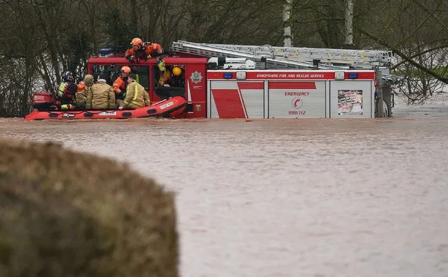 Members of the Fire and Rescue Service rescue colleagues trapped by flood water in a stranded Fire Engine, or appliance, after the River Teme burst its banks in Lindridge, western England, on February 16, 2020, after Storm Dennis caused flooding across large swathes of Britain. As Storm Dennis sweeps in, the country is bracing itself for widespread weather disruption for the second weekend in a row. Experts have warned that conditions amount to a “perfect storm”, with hundreds of homes at risk of flooding. (Photo by Oli Scarff/AFP Photo)