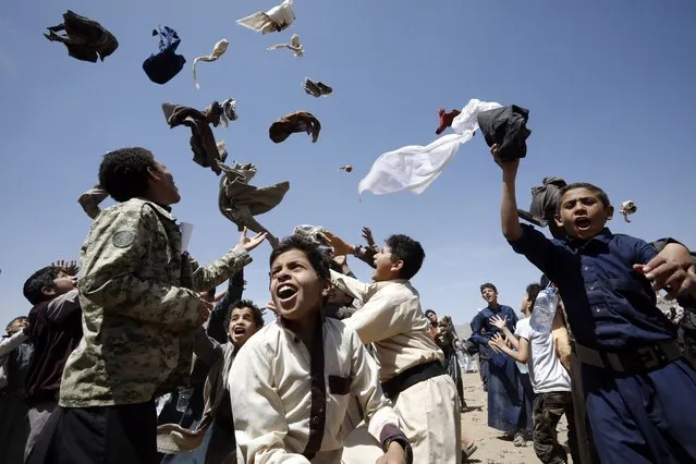 Yemeni boys toss pieces of their clothes in the air on a hot day, in Sana'a, Yemen, 06 June 2022. The Yemen meteorological service has warned of a heatwave and dry weather in most parts of the Arab country which is experiencing the lack of much needed rainfall. (Photo by Yahya Arhab/EPA/EFE)