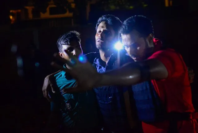 A Bangladeshi policeman that was injured during an attack on an upscale restaurant is helped by others in Dhaka on July 1, 2016. Heavily armed militants murdered 20 hostages in Bangladesh, hacking many of their victims to death, before six of the attackers were gunned down at the end of a siege July 2 at a restaurant packed with foreigners. As the Islamic State (IS) group claimed responsibility for the carnage at the start of the Eid holiday, Prime Minister Sheikh Hasina said she was determined to eradicate militancy in the mainly Muslim nation. (Photo by AFP Photo/Stringer)