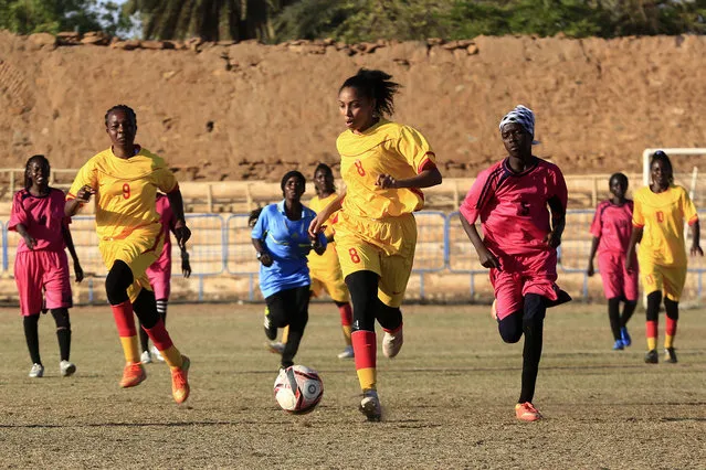 In this Wednesday, December 11, 2019 photo, Sudanese al-Difaa, in pink, and al-Sumood women teams play in Omdurman, Khartoum's twin city, Sudan. The women's soccer league has become a field of contention as Sudan grapples with the transition from three decades of authoritarian rule that espoused a strict interpretation of Islamic Shariah law. (Photo by AP Photo/Stringer)