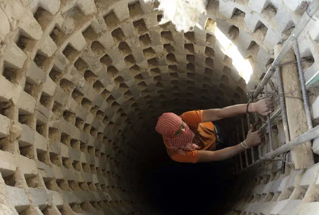 A Palestinian smuggler climbs down into a tunnel, temporarily closed by Hamas forces, beneath the Egyptian-Gaza border in Rafah in the southern Gaza Strip April 14, 2010. (Photo by Ibraheem Abu Mustafa/Reuters)