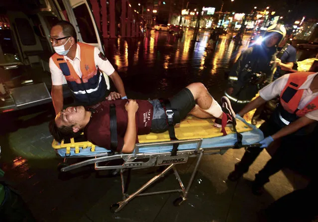An injured man is helped by emergency rescue workers after an explosion on a passenger train in Taipei, Taiwan, Thursday, July 7, 2016. Taiwan's official news agency says an explosion that engulfed a commuter train car in flames has injured a number of people, some of them seriously. (Photo by Jerry Chen/AP Photo)
