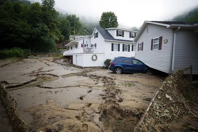 A house that was moved off of its foundation following a flash flood rests on top of a vehicle, Thursday, July 14, 2022 in Whitewood, Va. Virginia Gov. Glenn Youngkin declared a state of emergency to aid in the rescue and recovery efforts from Tuesday's floodwaters. (AP Photo/Michael Clubb)