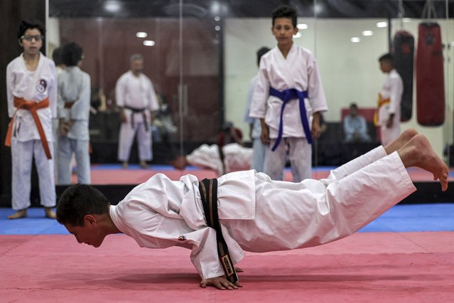 Palestinian karate students practice yoga at a dojo on the occasion of International Yoga Day in the city of Ramallah in the occupied West Bank on June 21, 2022.  (Photo by Abbas Momani/AFP Photo)