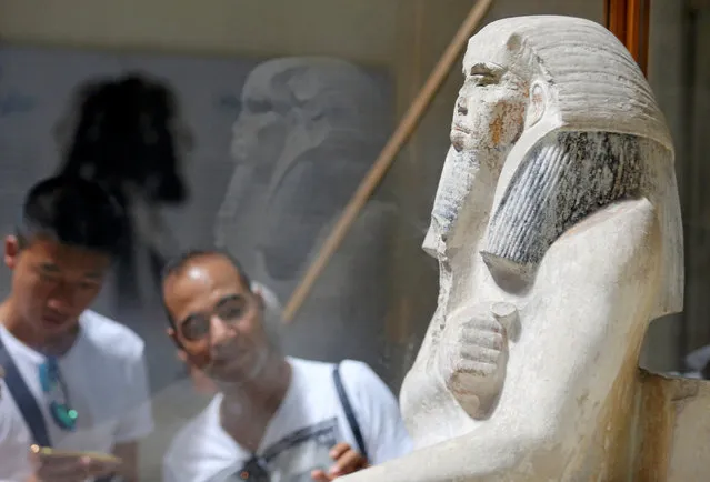 Tourists look at pharaonic artefact inside the Egyptian Museum during the summer season in Cairo, Egypt, July 14, 2016. (Photo by Mohamed Abd El Ghany/Reuters)