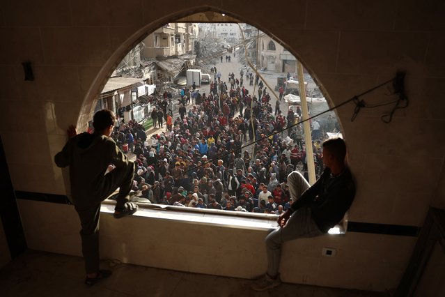 Palestinians wait in a queue to receive bread outside a bakery in Khan Yunis on November 18, 2024, amid the ongoing war between Israel and Hamas. (Photo by Bashar Taleb/AFP Photo)
