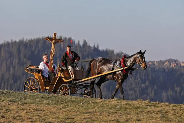 A priest holds a cross in a horse-drawn cart during Good Friday celebrations in the mountains following the spread of coronavirus disease (COVID-19), in Zakopane, Poland on April 10, 2020. (Photo by Marek Podmokly/Agencja Gazeta via Reuters)