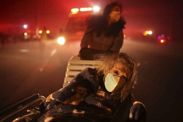 A resident of a senior center is evacuated as the Eaton Fire approaches Tuesday, January 7, 2025 in Altadena, Calif. (Photo by Ethan Swope/AP Photo)