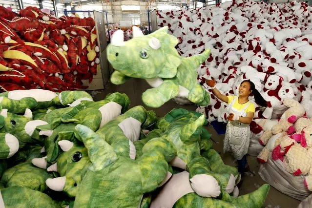 This picture taken on September 6, 2015 shows a Chinese worker stacking soft toys at a factory before packing them for export, in Lianyungang, China's Jiangsu province. China on September 7 lowered its GDP growth figure for last year by 0.1 percentage points to 7.3 percent, authorities said, as concerns mount over slowing expansion in the world's second-largest economy. (Photo by AFP Photo)