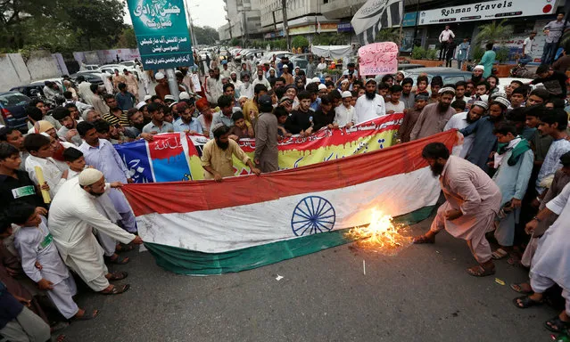 Supporters of Islamic charity organization Jamaat-ud-Dawa (JuD) chant anti-India slogans as they burn flag during a protest against the visit of Indian Interior Minister Rajnath Singh, during a demonstration in Karachi, Pakistan, August 3, 2016. (Photo by Akhtar Soomro/Reuters)