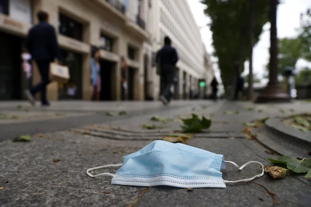 A face mask is seen on the floor on the Champs Elysee avenue in Paris, France, 11 May 2020. France began a gradual easing of its lockdown ​measures and restrictions amid the COVID-19 pandemic. (Photo by Ian Langsdon/EPA/EFE)
