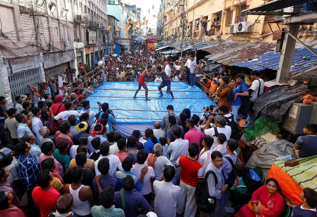Wrestlers fight during an amateur wrestling match inside a makeshift ring installed on a road organised by local residents as part of Diwali, the festival of lights, celebrations in Kolkata, India on October 19, 2017. (Photo by Rupak De Chowdhuri/Reuters)