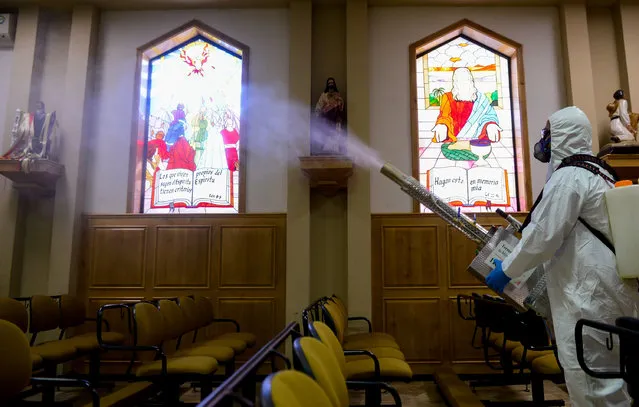 A worker in a protective suit sprays dissinfectant the Sagrada Familia church as a measure of protection against the coronavirus pandemic, in Ciudad Juarez, Chihuahua, Mexico, 25 May 2020. The Churches in Ciudad Juarez plan to open their doors on 01 June. (Photo by Luis Torres/EPA/EFE/Rex Features/Shutterstock)