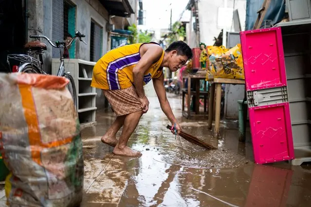 A man clears the street from mud following the flood caused by Super Typhoon Noru, in Marikina City, Metro Manila, Philippines on September 26, 2022. (Photo by Lisa Marie David/Reuters)