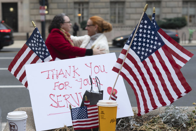 Flags and a sign thanking United States Agency for International Development (USAID) workers are pictured as USAID workers retrieve their personal belongings from USAID's headquarters in Washington, Thursday, February 27, 2025, in Washington. (Photo by Manuel Balce Ceneta/AP Photo)