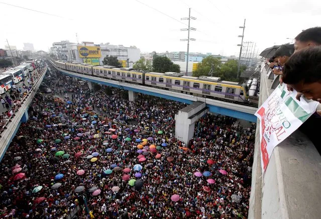 Thousands of residents, mostly affiliated with the Christian sect the Iglesia Ni Cristo (Church of Christ), gather at an intersection to receive relief supplies from one of the country's largest Christian sects, in Manila, Philippines, Monday, October 14, 2013. (Photo by Bullit Marquez/AP Photo)