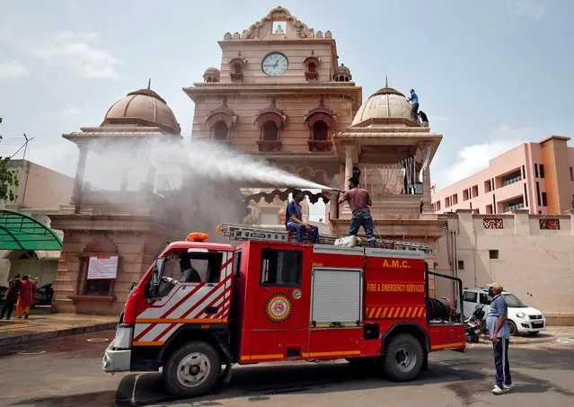 Firefighters spray disinfectant on the Lord Jagannath temple, after authorities eased lockdown restrictions that were imposed to slow the spread of the coronavirus disease (COVID-19), in Ahmedabad, June 15, 2020. (Photo by Amit Dave/Reuters)